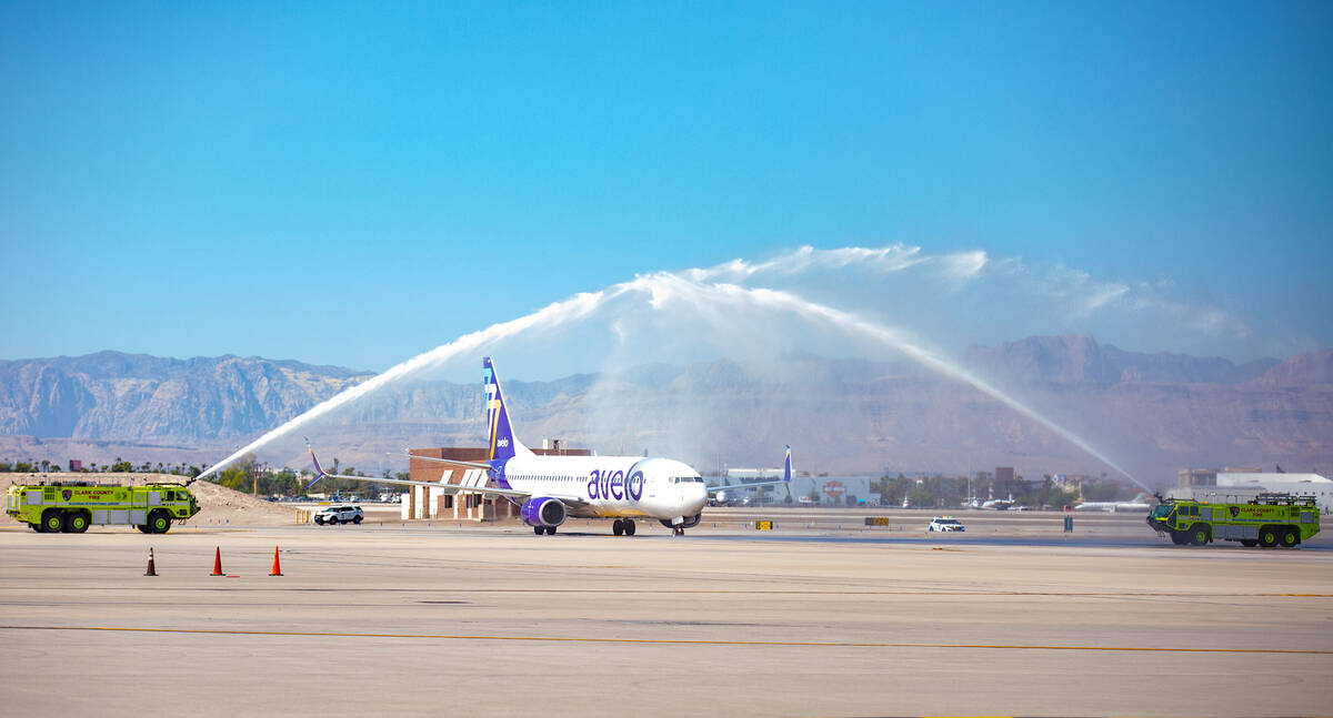 A Boeing 737-800 jet operated by Avelo Airlines taxis beneath a water arch at McCarran Internat ...