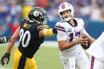Buffalo Bills quarterback Josh Allen (17) runs past Pittsburgh Steelers linebacker T.J. Watt (9 ...