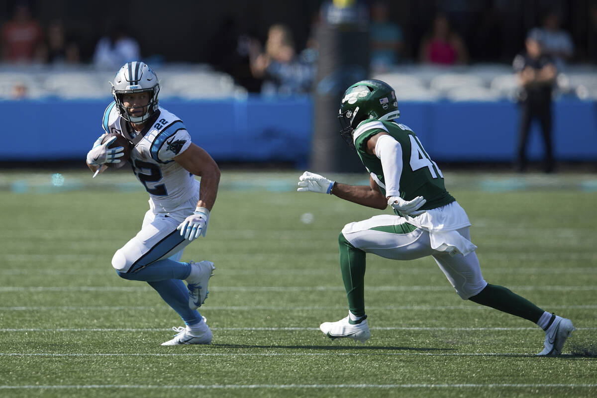 Carolina Panthers running back Christian McCaffrey (22) tries to avoid the tackle attempt of Ne ...