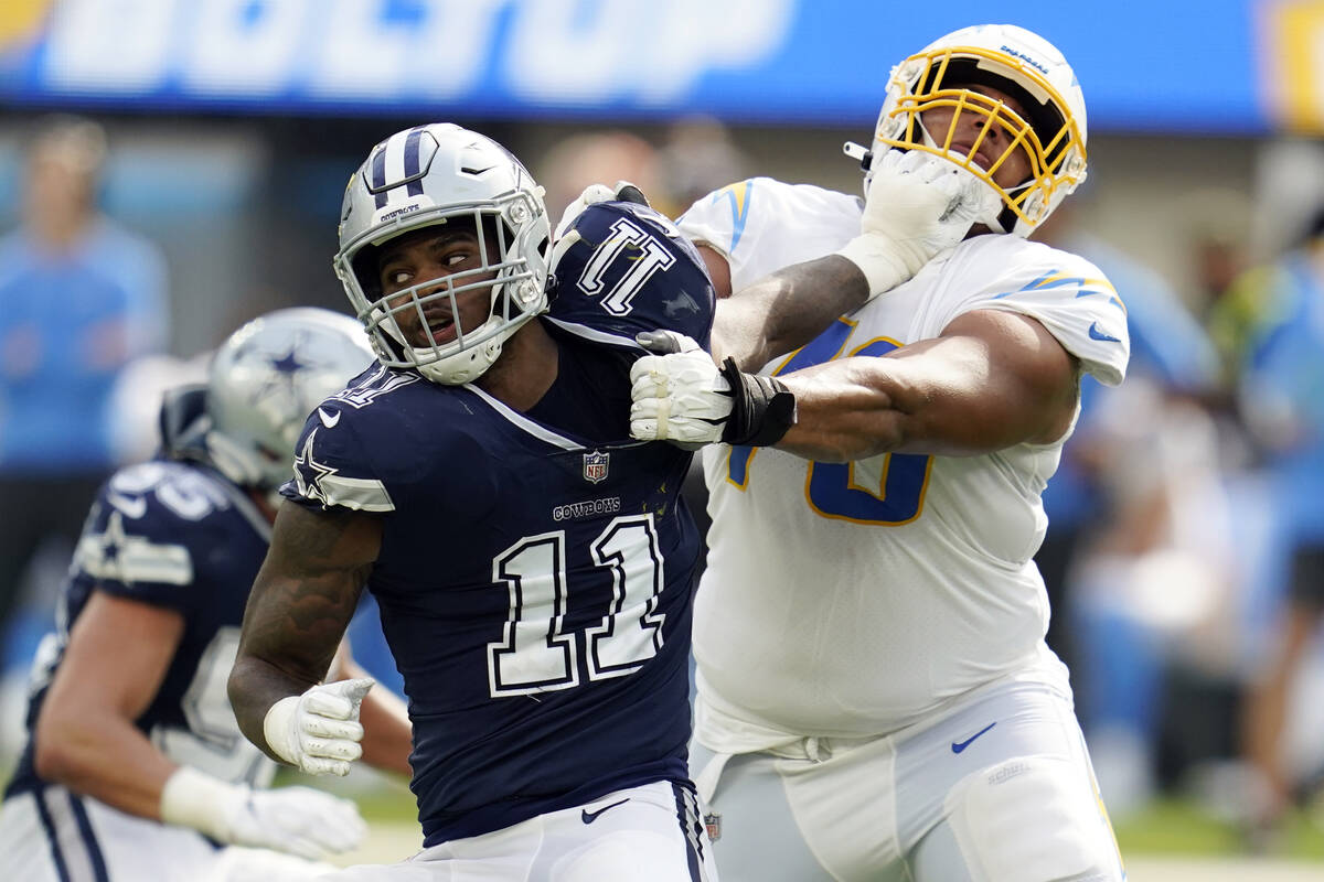 Dallas Cowboys linebacker Micah Parsons (11) is tackled by Los Angeles Chargers offensive tackl ...