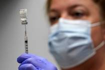 In this March 2, 2021, file photo, Hollie Maloney, a pharmacy technician, loads a syringe with ...