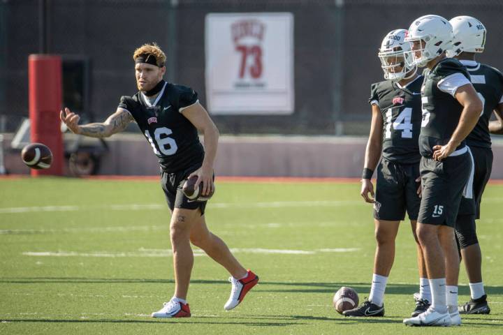 UNLV quarterback Tate Martell (16, left) tosses in a ball to a teammate as other quarterbacks l ...
