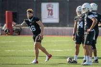 UNLV quarterback Tate Martell (16, left) tosses in a ball to a teammate as other quarterbacks l ...