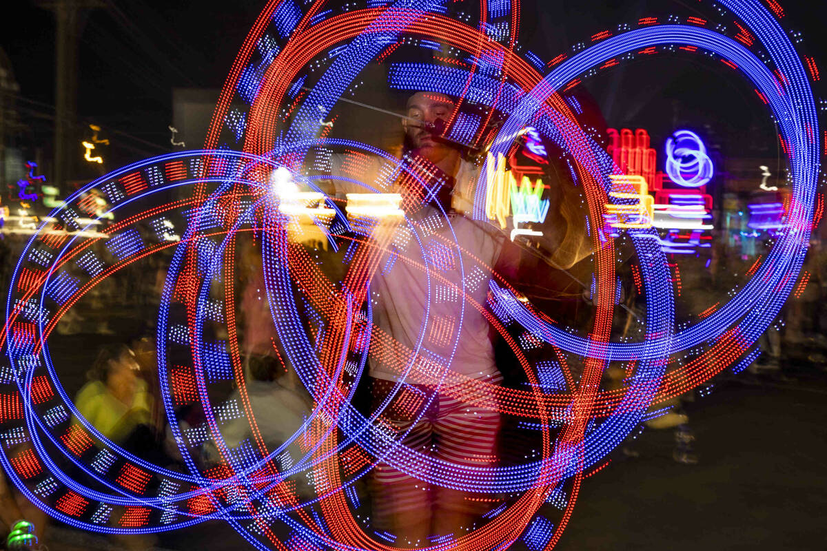 Matt Warnock of Las Vegas twirls some LED sticks during day one of Life is Beautiful on Friday, ...