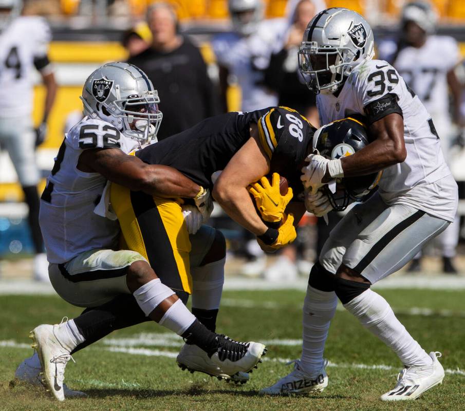 Raiders middle linebacker Denzel Perryman (52) and Raiders cornerback Nate Hobbs (39) tackle Pi ...