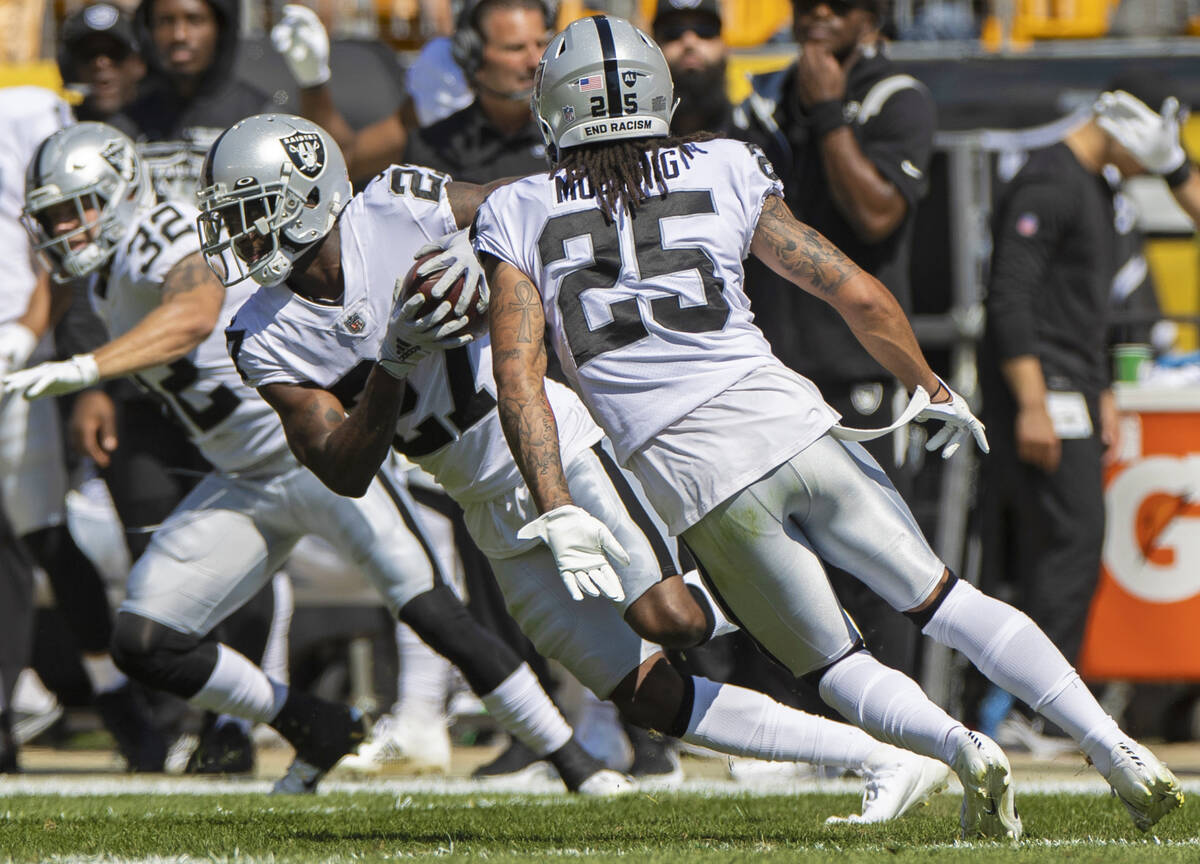 Raiders cornerback Trayvon Mullen (27) runs back an interception with teammates Raiders safety ...