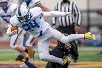 Moapa Valley's Gunner Redd (24) is taken down in the backfield by Faith Lutheran's Chandler Sil ...