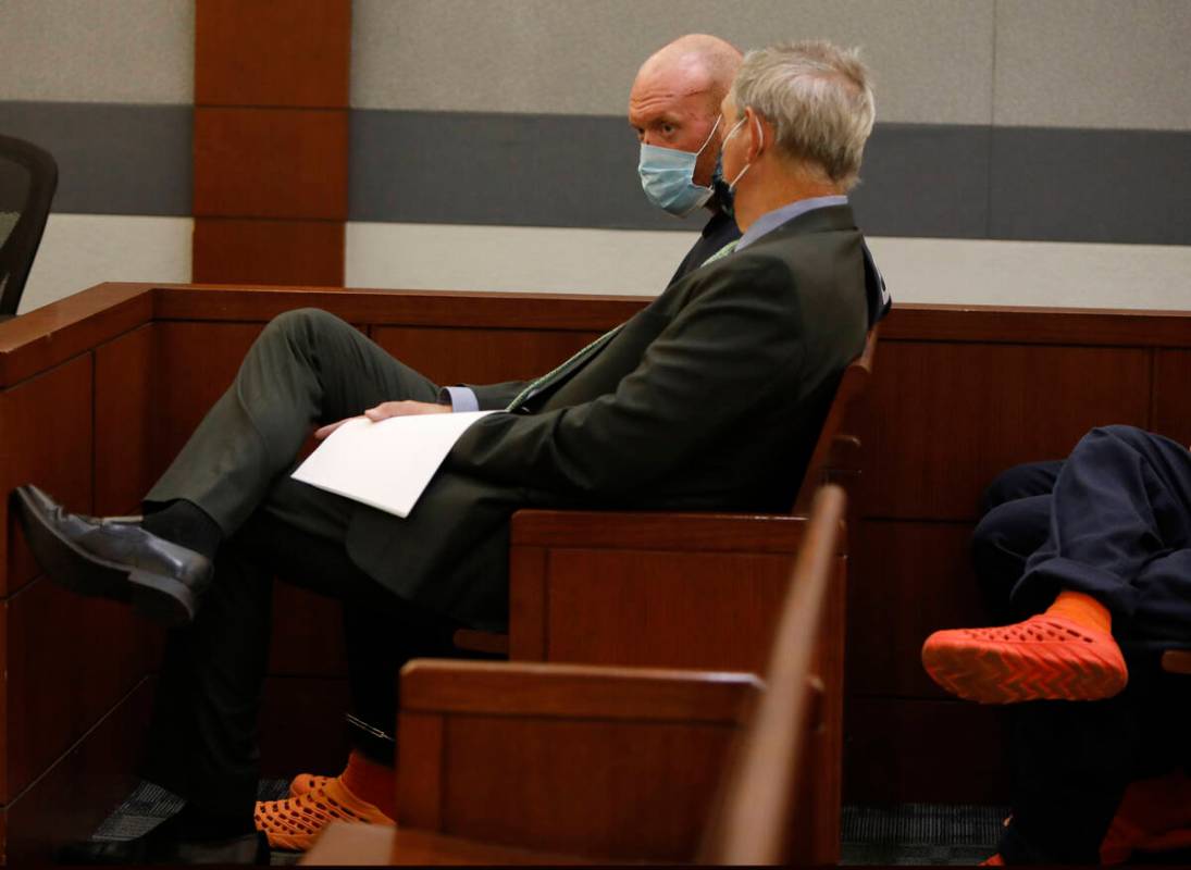 New Haven police officer Robert Ferraro, face to camera, listens to his attorney Gabriel Grasso ...