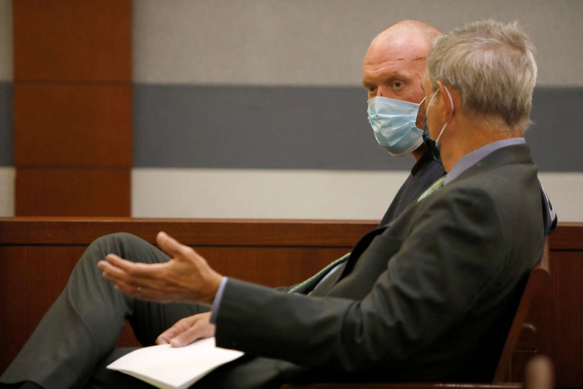 New Haven police officer Robert Ferraro, face to camera, listens to his attorney Gabriel Grasso ...
