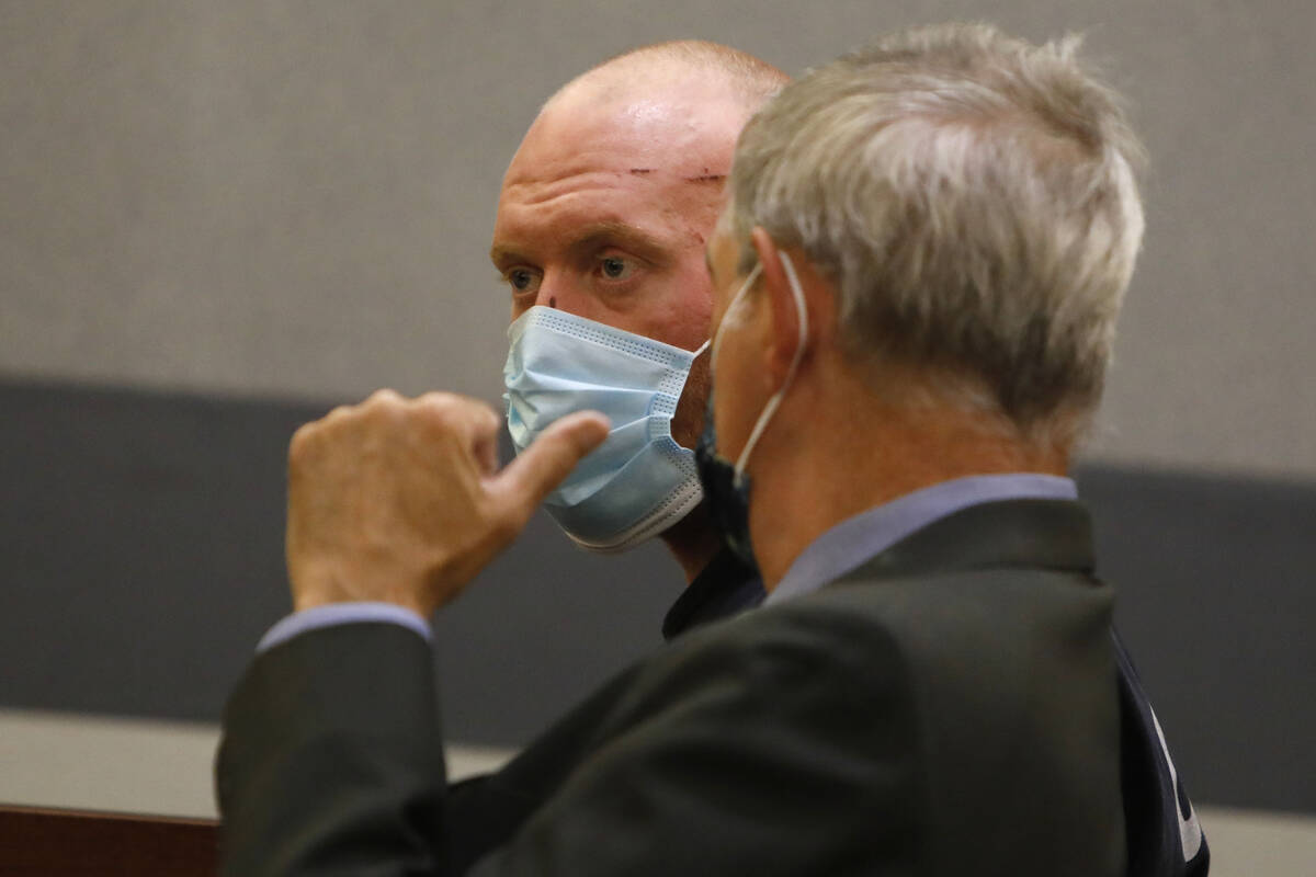 New Haven police officer Robert Ferraro, face to camera, listens to his attorney Gabriel Grasso ...
