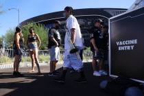 People line up to get the COVID-19 vaccine before the start of an NFL football game between the ...