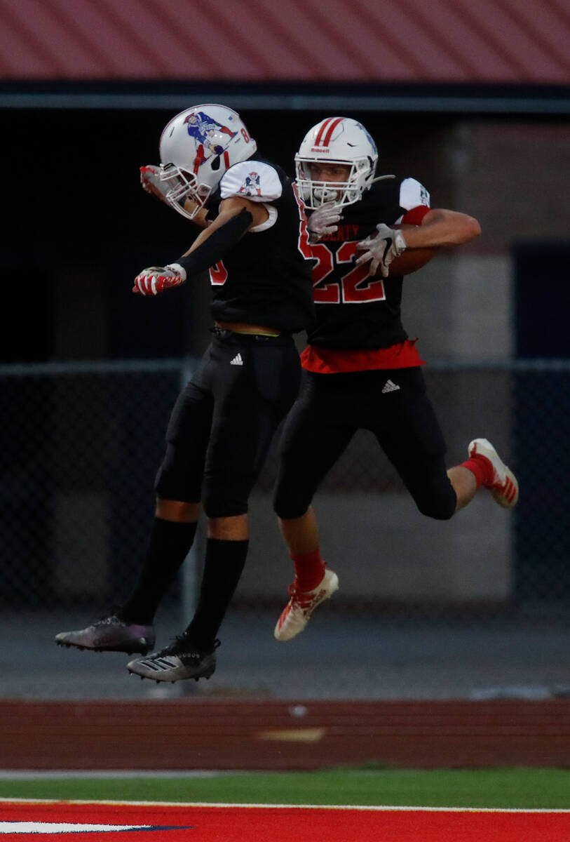Liberty High School's Brody Clark (22) celebrates his touchdown with Jae Beasley (88) during t ...