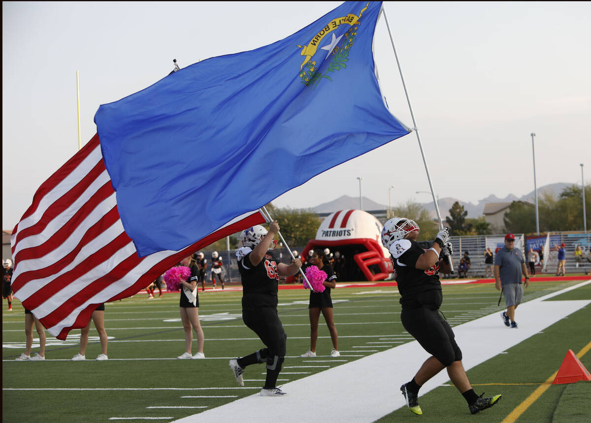 Liberty High School's Phillip Ewell (63), left and Guillermo Medina (52), right, carry flags wh ...