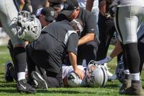 Raiders quarterback Derek Carr (4) remains down after getting hit as he threw a touchdown pass ...