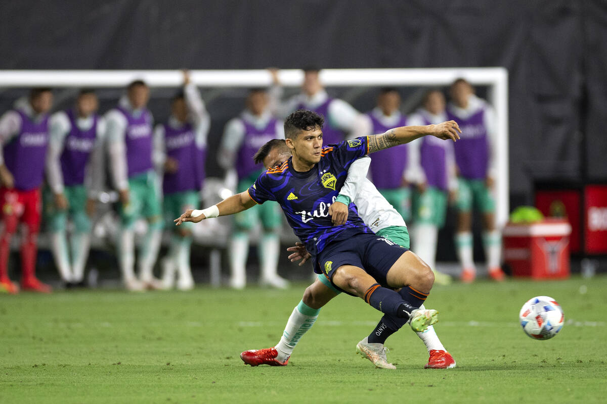 Seattle Sounders forward Fredy Montero (12) passes as Len midfielder Angel Mena (13) falls behi ...