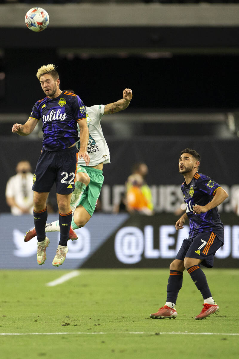 Seattle Sounders midfielder Kelyn Rowe (22) and Leon midfielder Santiago Colombatto (22) jump f ...