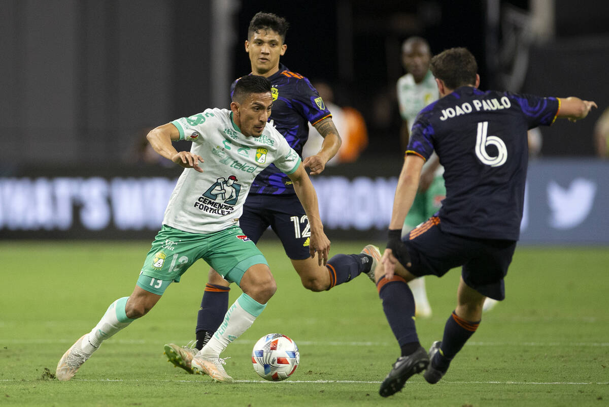 Leon midfielder Angel Mena (13) attempts to run through Seattle Sounders midfielder Joao Paulo ...