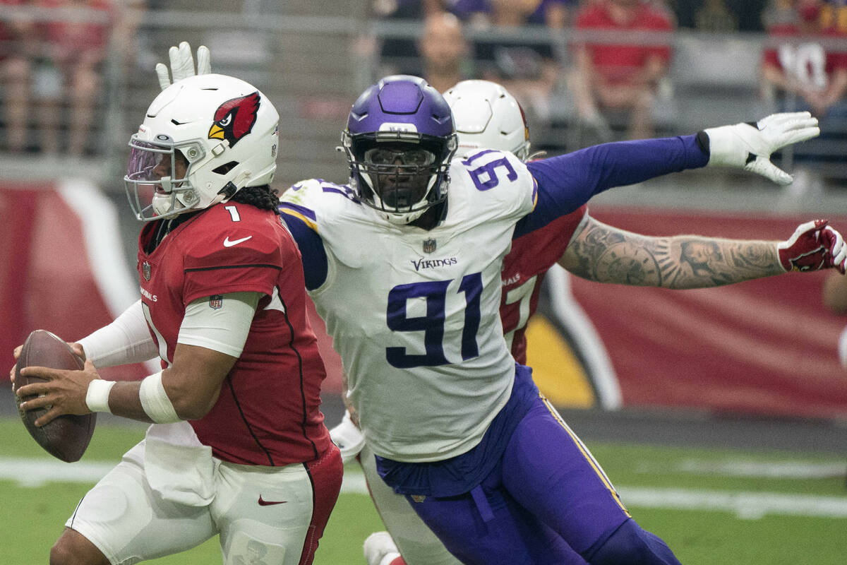 Arizona Cardinals' Kyler Murray 1,runs away from Minnesota Vikings' Stephen Weatherly 91, durin ...
