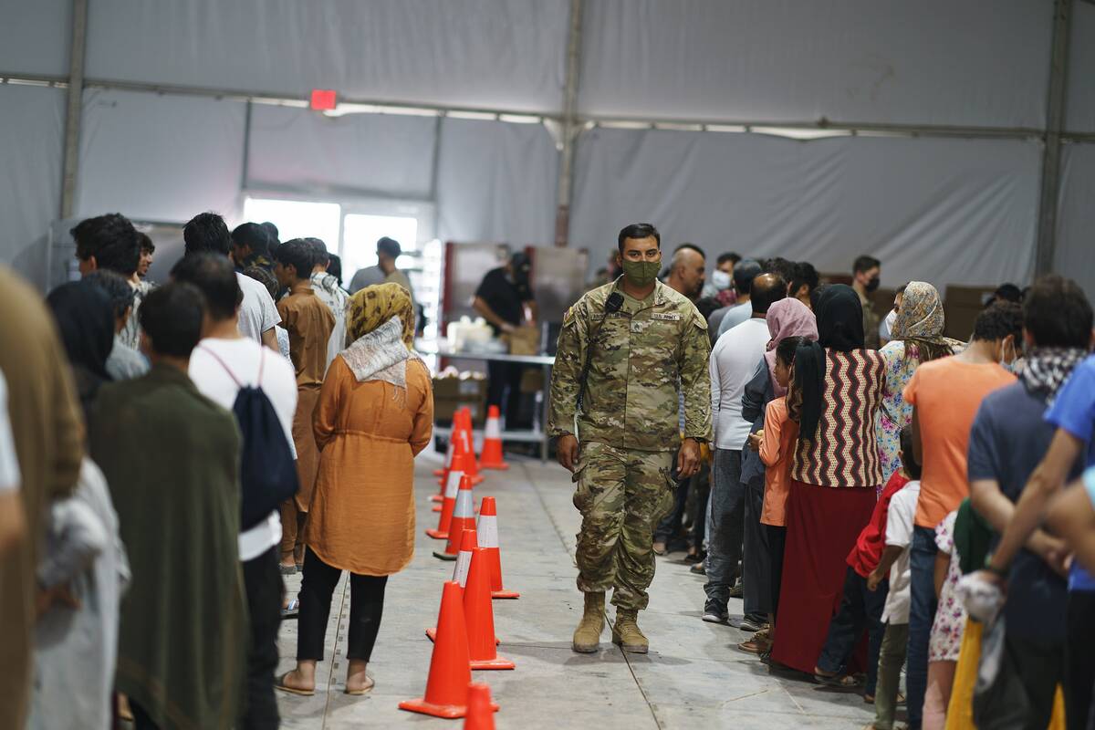 Afghan refugees line up for food in a dining hall at Fort Bliss' Doña Ana Village where th ...