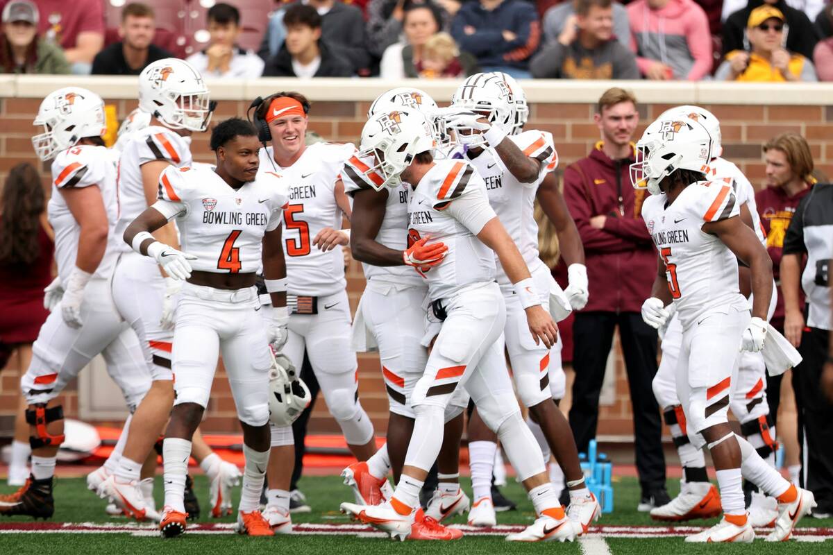 Bowling Green quarterback Matt McDonald (3) celebrates with teammates on the sideline after sco ...