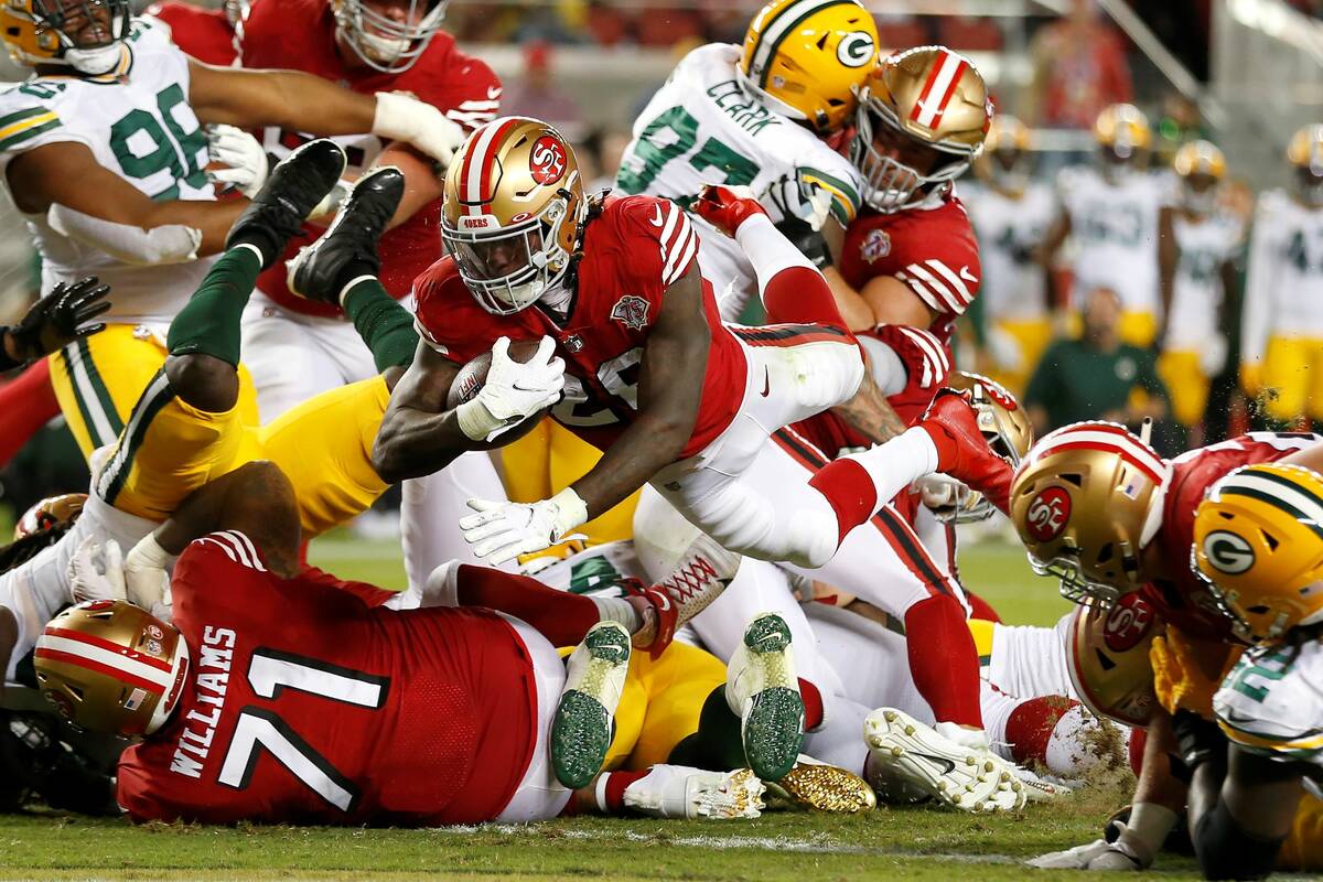 San Francisco 49ers running back Trey Sermon, middle, runs for a touchdown against the Green Ba ...