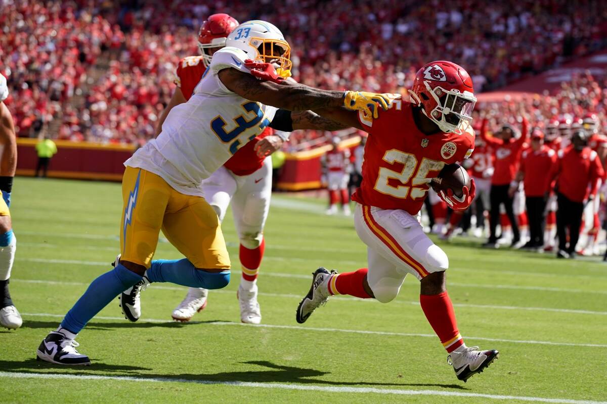 Kansas City Chiefs' Clyde Edwards-Helaire (25) runs past Los Angeles  Chargers' Derwin James (33 …