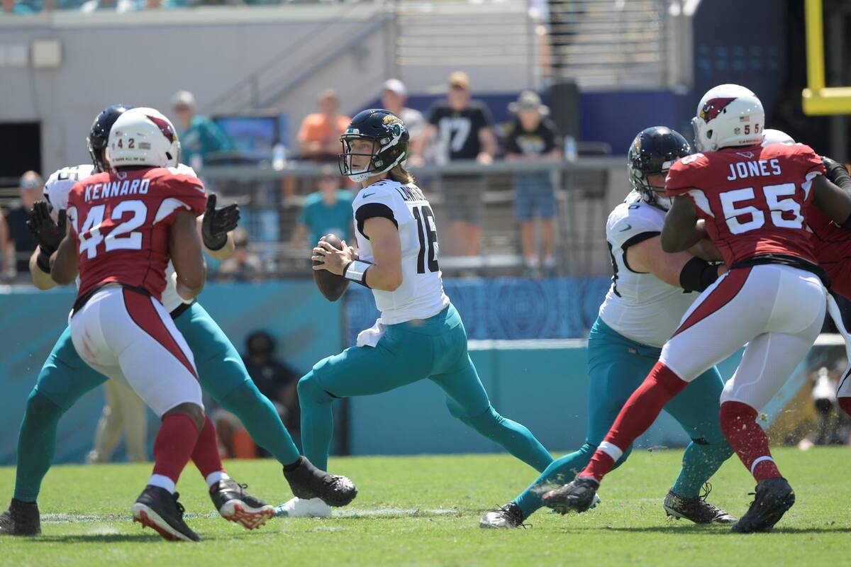 Jacksonville Jaguars quarterback Trevor Lawrence (16) looks for a receiver as Arizona Cardinals ...