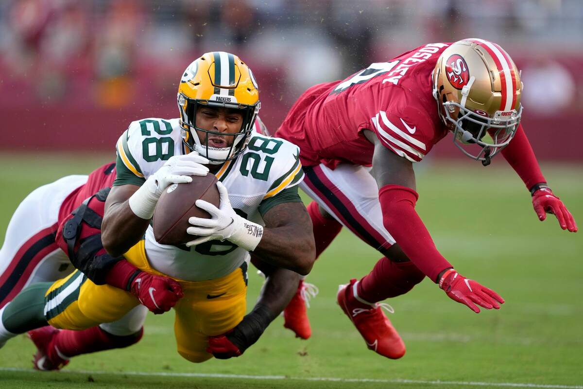 Green Bay Packers running back A.J. Dillon (28) is tackled by San Francisco 49ers linebacker Az ...