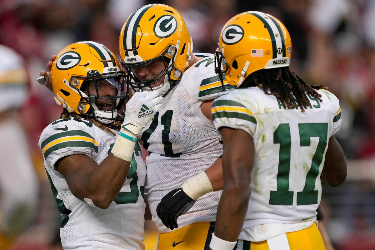 Green Bay Packers running back Aaron Jones, left, is congratulated by center Josh Myers, middle ...