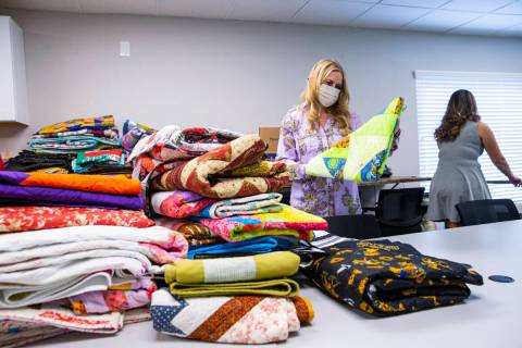 Tennille Pereira, director of the Vegas Strong Resiliency Center, looks through donated quilts ...