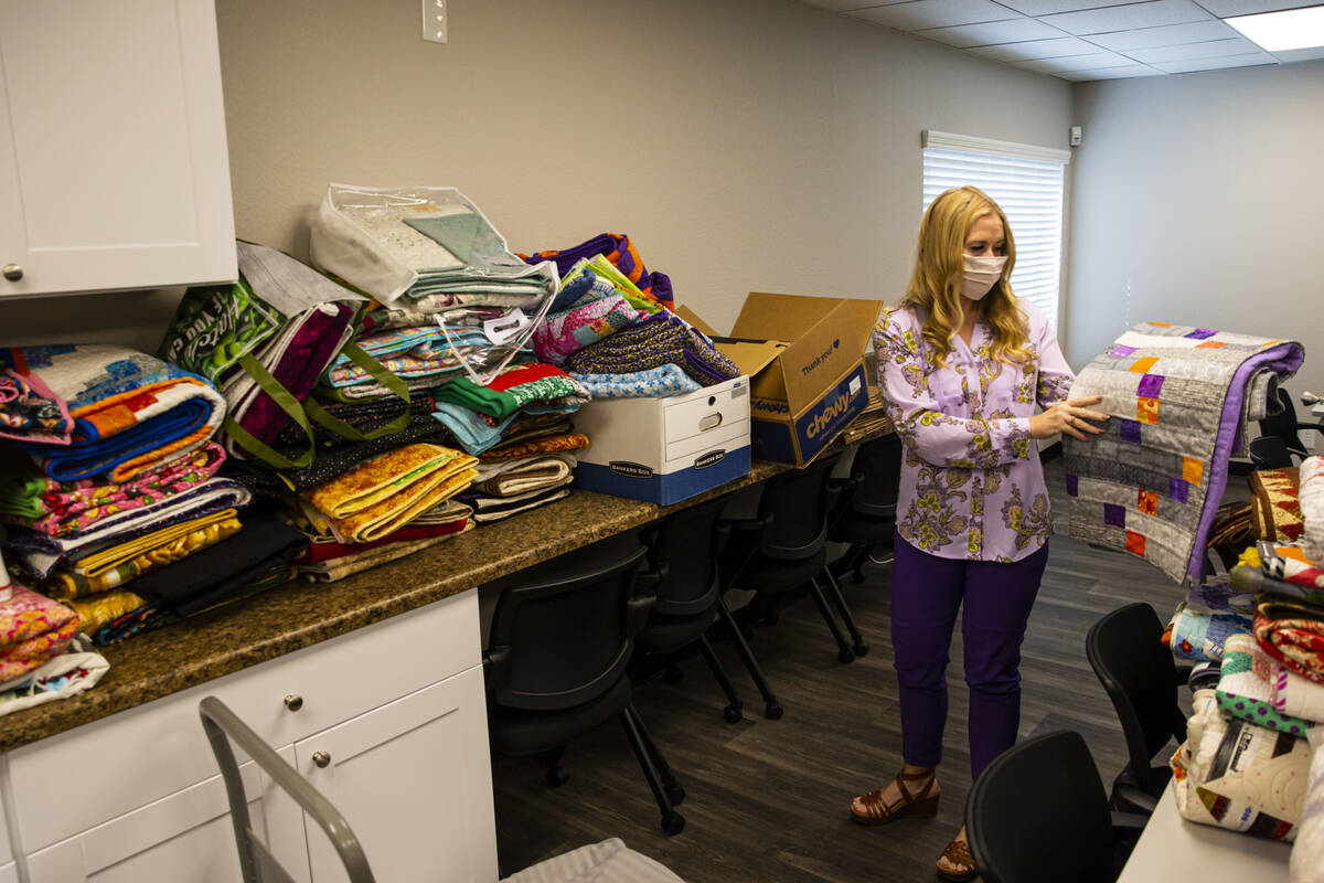 Tennille Pereira, director of the Vegas Strong Resiliency Center, holds a donated quilt featuri ...