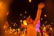 Keira Wang, 5, from Rosemead, Calif., watches lanterns be released during the RiSE festival on ...