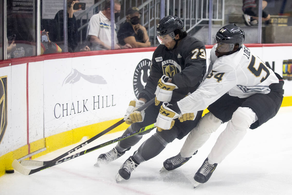 Golden Knights forward Gage Quinney (73) and forward Jermaine Loewen (54) compete for the puck ...
