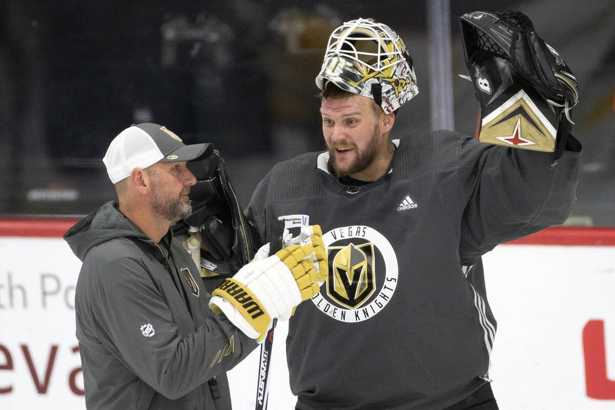 Golden Knights coach Peter DeBoer speaks with goaltender Robin Lehner (90) during a NHL hockey ...