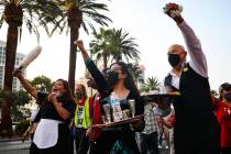 Nympha Comacchio, from left, Cristina Kline, center, and Jose Rivera, right, chant as they marc ...