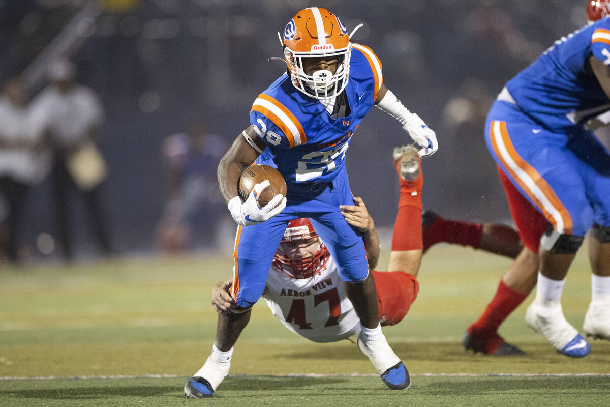 Bishop Gorman's Chandler Shulman (28) before getting tackled by Arbor View's Bryce Ericson (47) ...