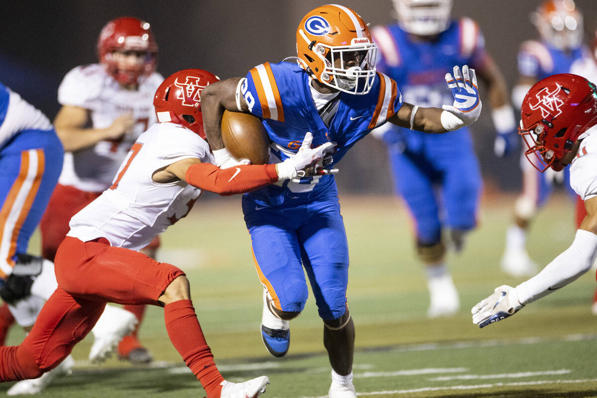 Bishop Gorman's Devon Rice (28) runs the ball before getting tackled by Arbor View's Aiden Powe ...