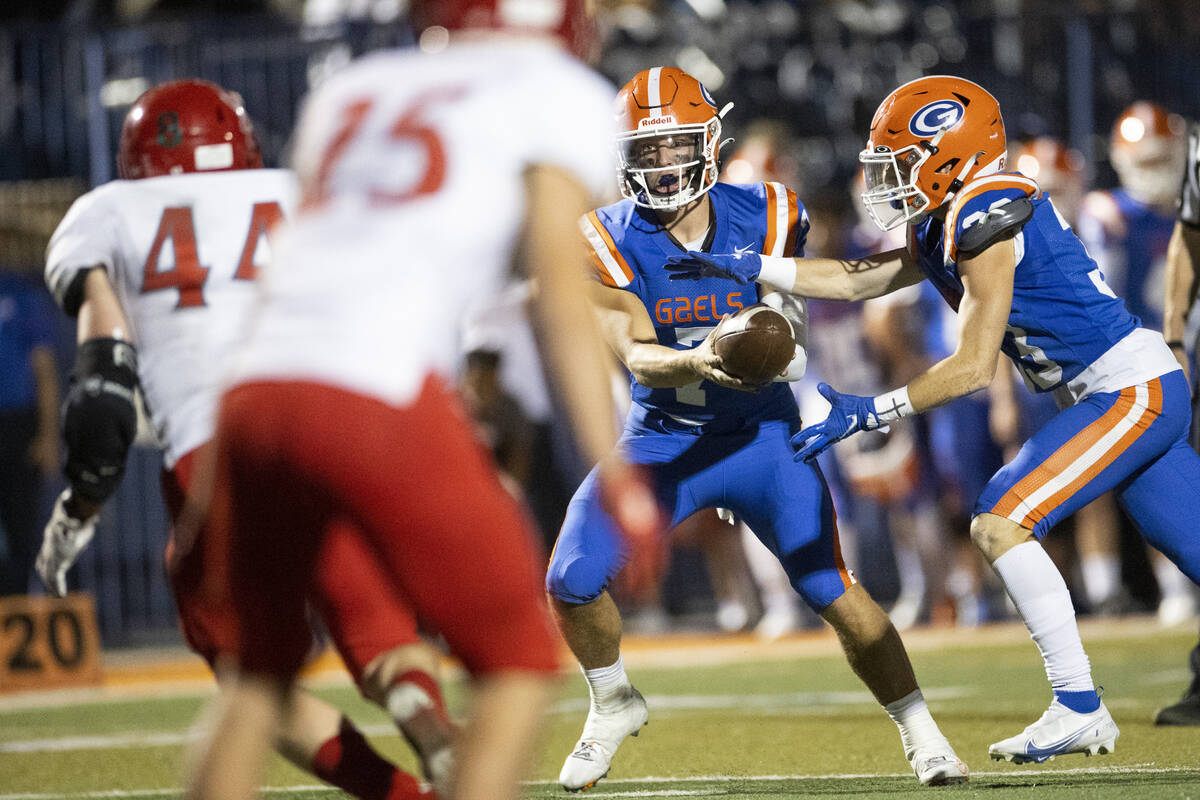 Bishop Gorman's Styles Stockham (7) hands off the ball to Rocco Scaldeferri (33) during the sec ...