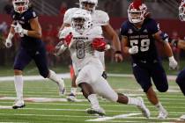 UNLV running back Charles Williams, center, runs for a big gain against Fresno State during the ...