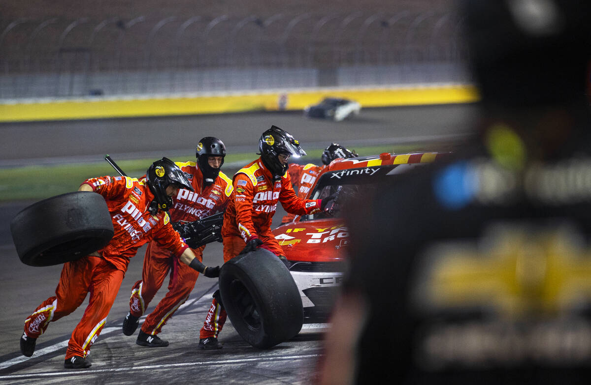 Pit crews work on a race car during the Alsco Uniforms 302 NASCAR Xfinity series race on Saturd ...