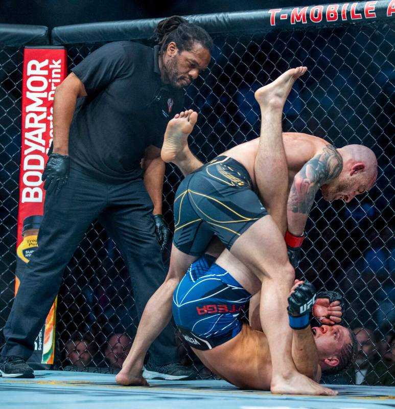 Alexander Volkanovski, above, looks down on Brian Ortega in the third round during their feathe ...