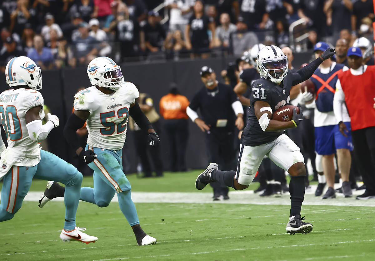 Raiders running back Peyton Barber (31) runs the ball in front of Miami Dolphins middle linebac ...