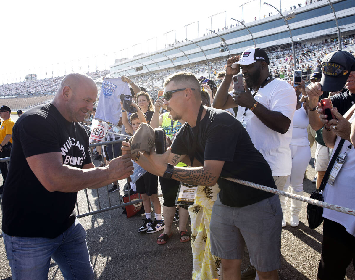 Dana White, left, president of the Ultimate Fighting Championship, signs autographs to fans dur ...