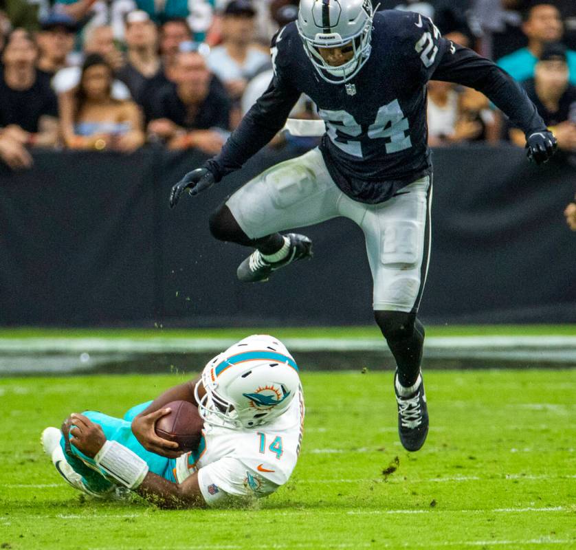 Miami Dolphins quarterback Jacoby Brissett (14) slides beneath Las Vegas Raiders defensive back ...