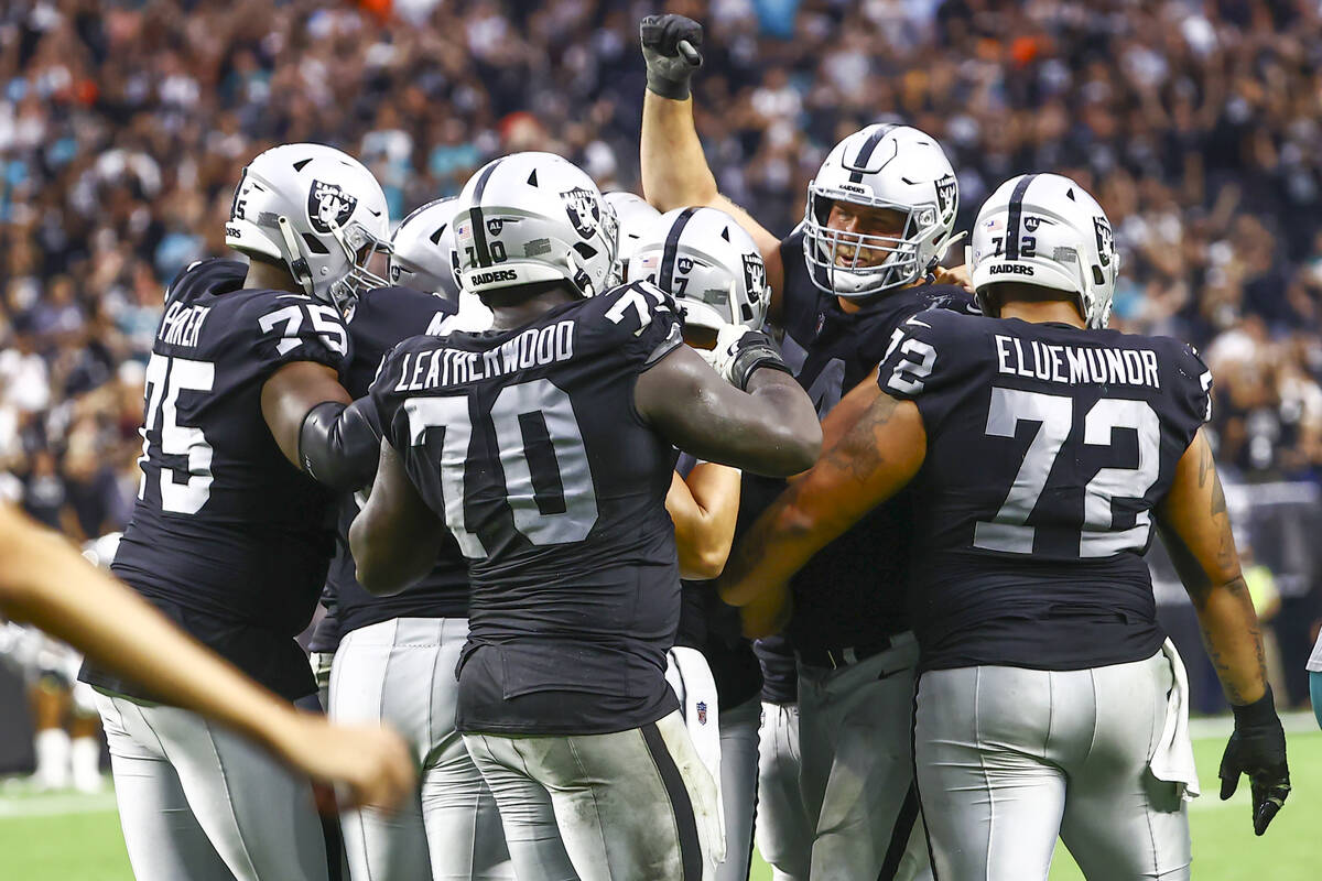 Raiders celebrate around kicker Daniel Carlson (2) after his game-winning field goal in overtim ...