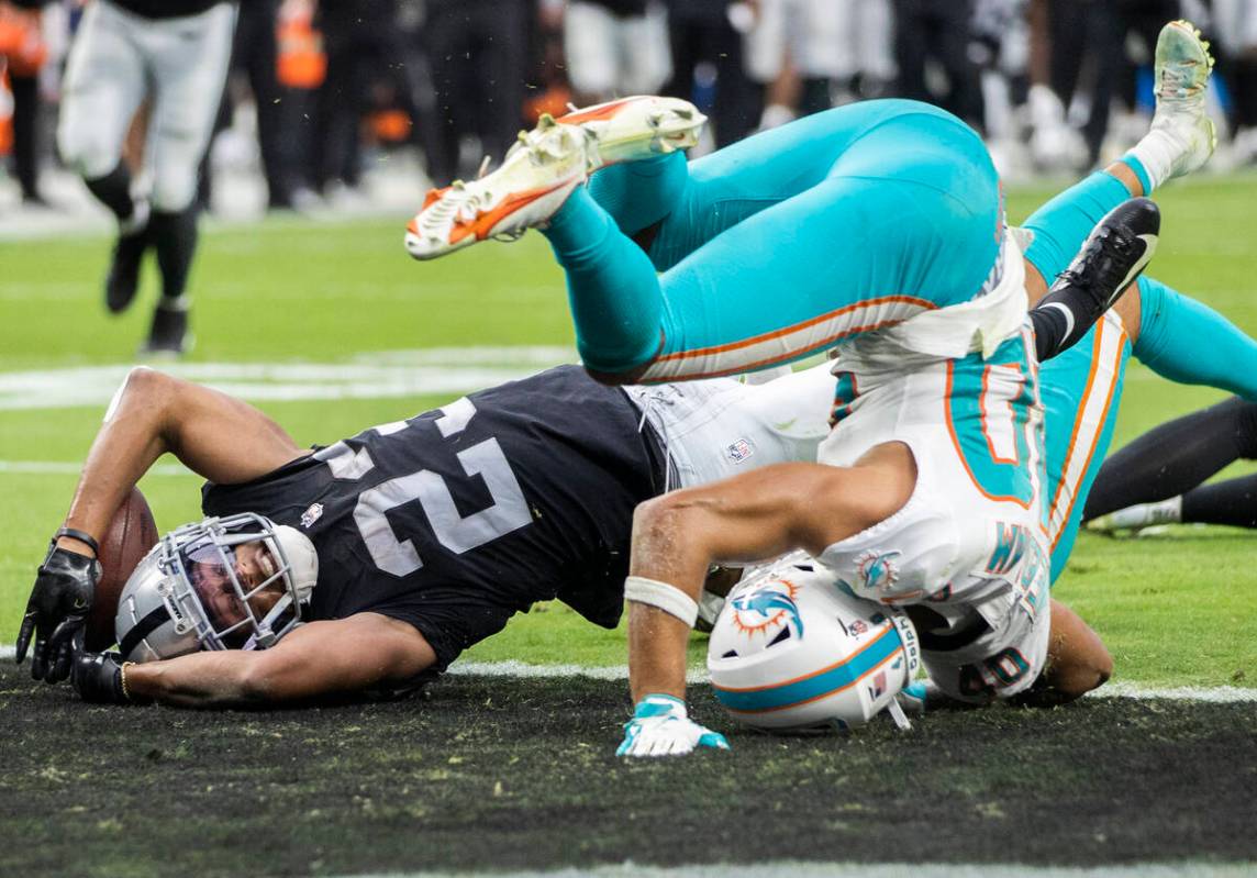 Las Vegas Raiders running back Kenyan Drake (23) reaches the ball into the end zone past Miami ...