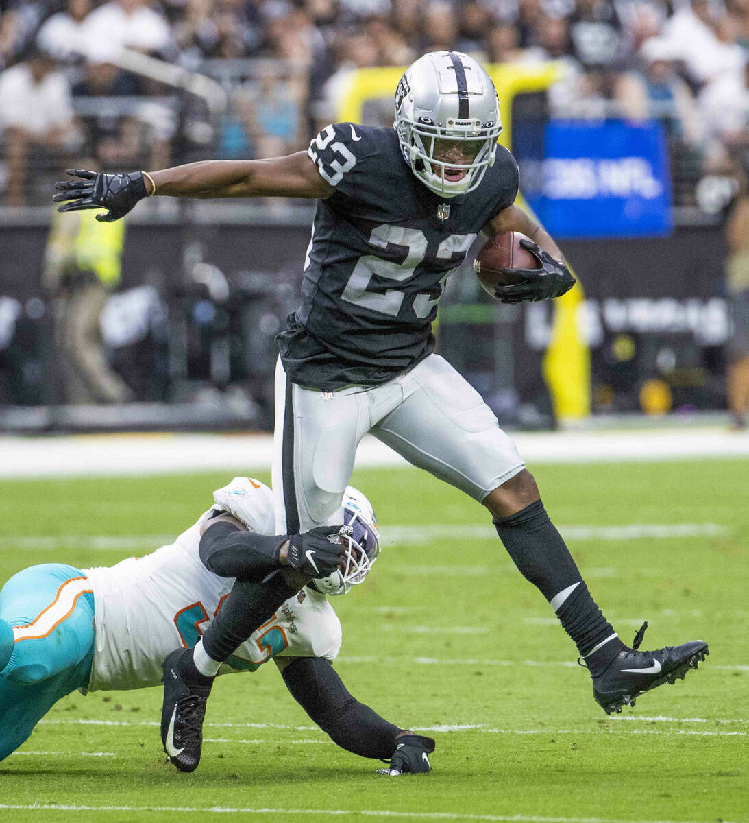 Las Vegas Raiders running back Kenyan Drake (23) looks to break a tackle by Miami Dolphins midd ...