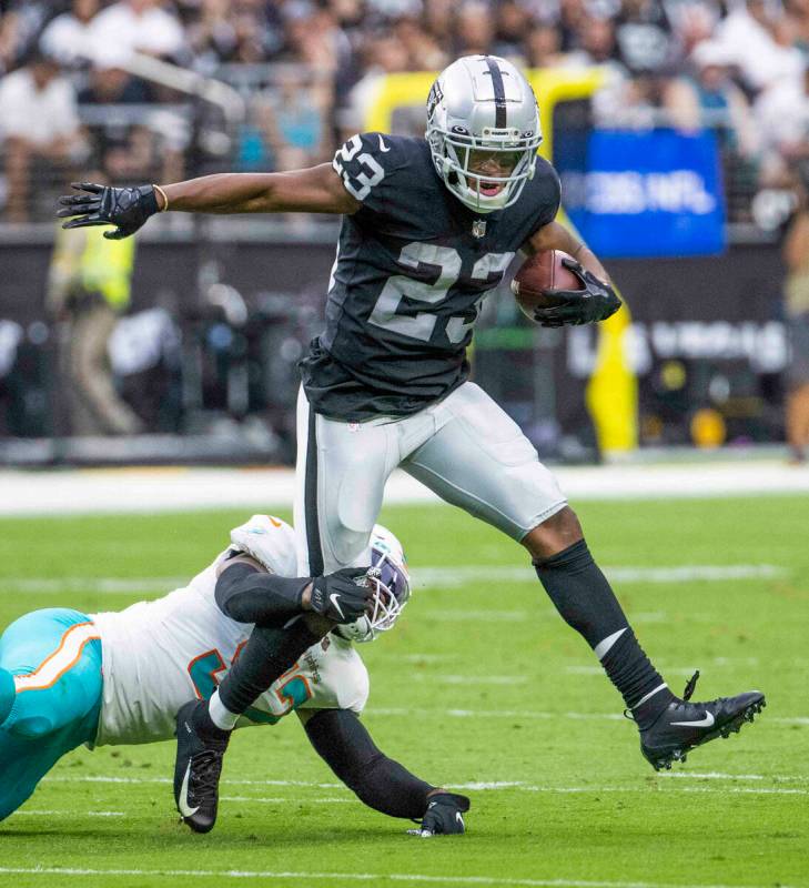 Las Vegas Raiders running back Kenyan Drake (23) looks to break a tackle by Miami Dolphins midd ...