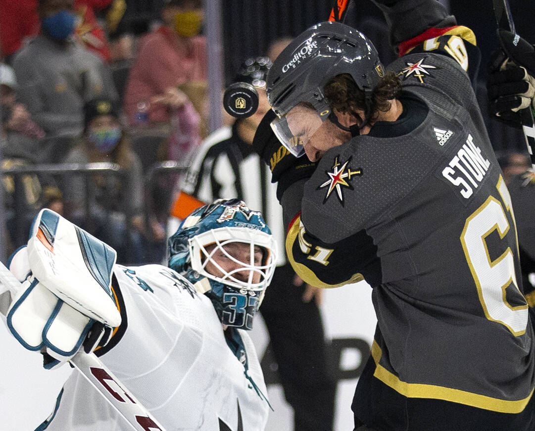 The puck is in the air after hitting the ear of Golden Knights right wing Mark Stone (61) takes ...