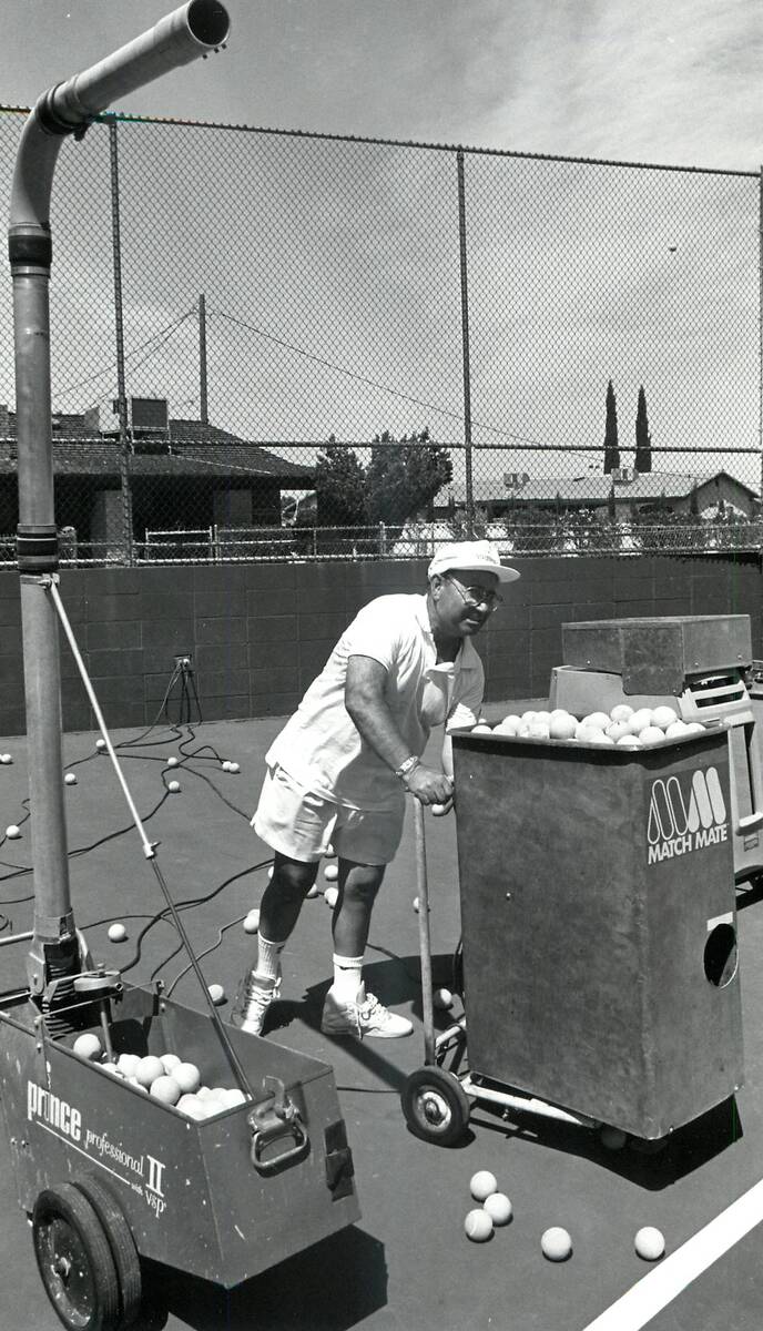 Mike Agassi, the father of Andre Agassi, loads and adjusts the ball machine used on the tennis ...